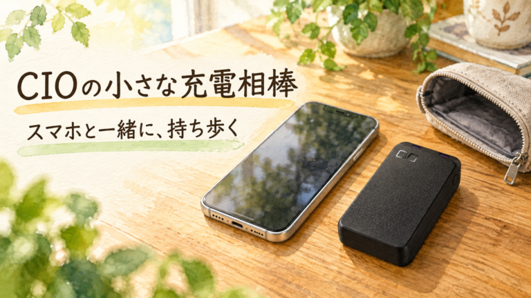 スマートフォンと開いたポーチのそばに置いた黒いCIOのバッテリー